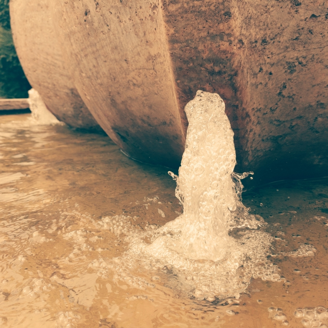 Eine Wasserfontäne an einem Brunnen.