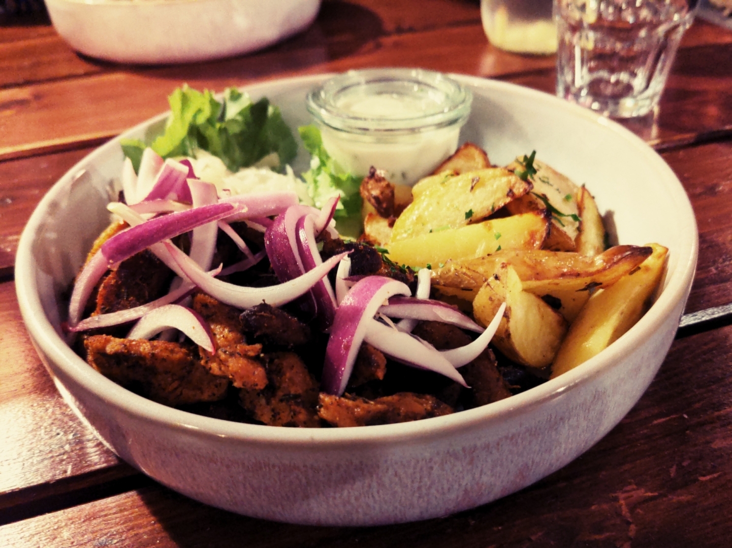Rosi-Teller (Sojagyros): Knuspriges Soja-Gyros, Ofen-Wedges, hausgemachter Krautsalat, Zwiebeln und Tzatziki