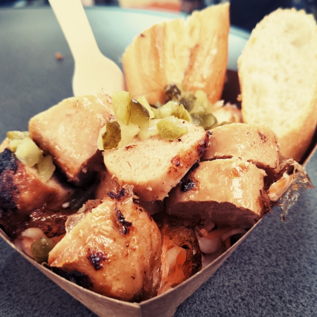 Vegane Bratwurst mit Krautsalat und Brot.