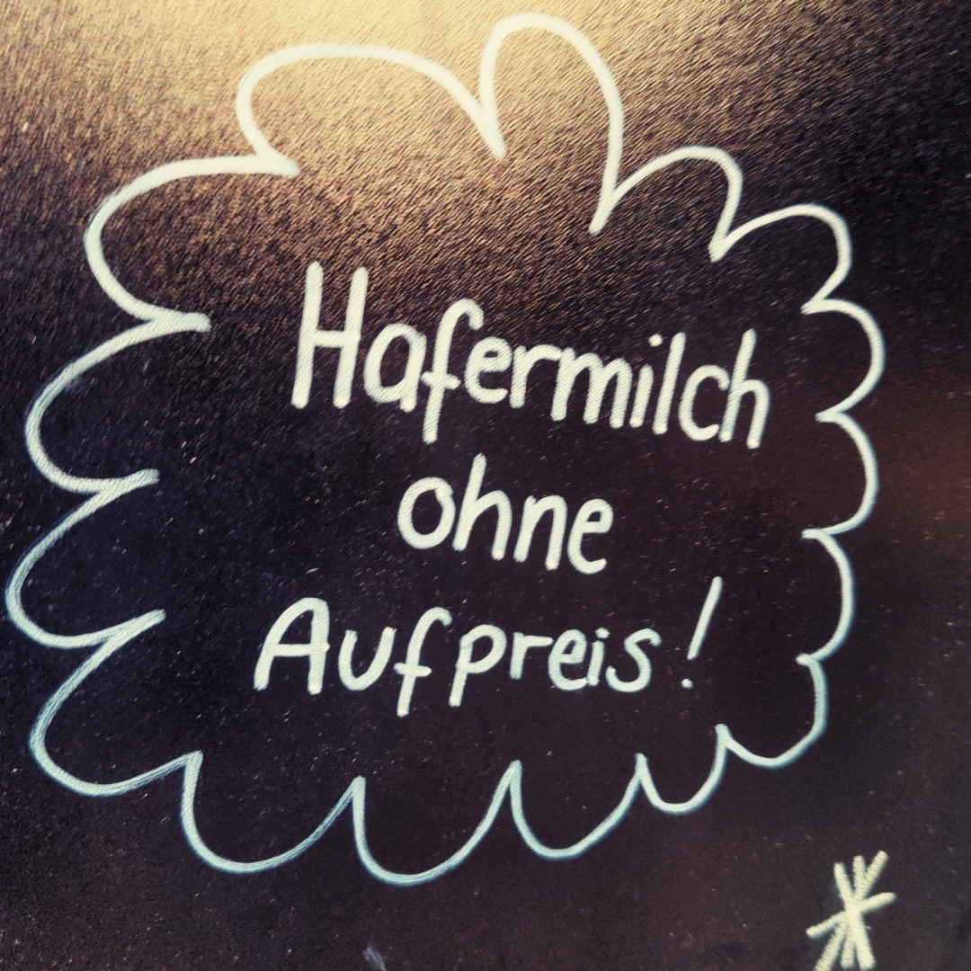 "Hafermilch ohne Aufpreis" auf einer Tafel.